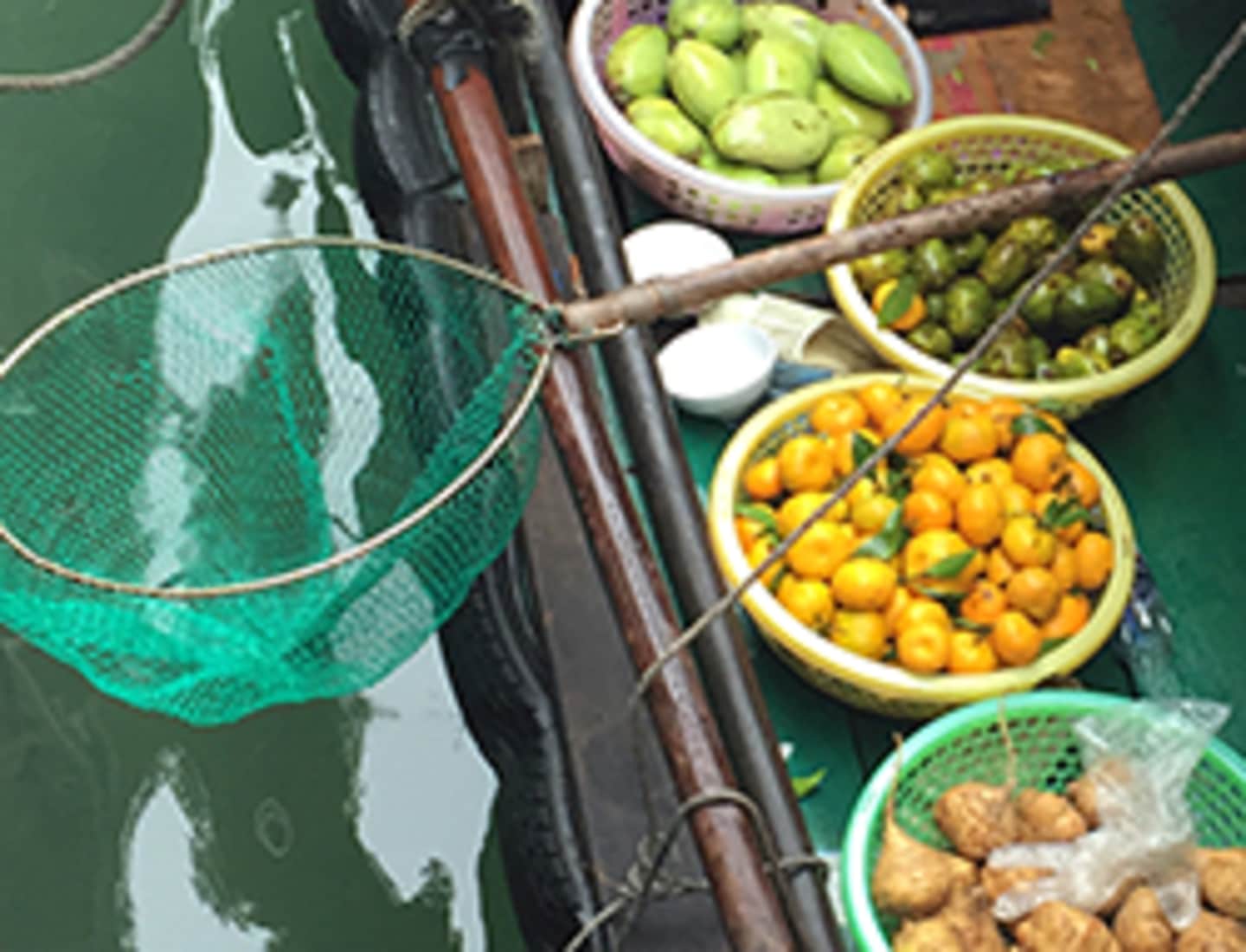The image shows a variety of fresh produce, including green pears, yellow peppers, and other unidentified fruits and vegetables, arranged on a wooden surface with a green background.