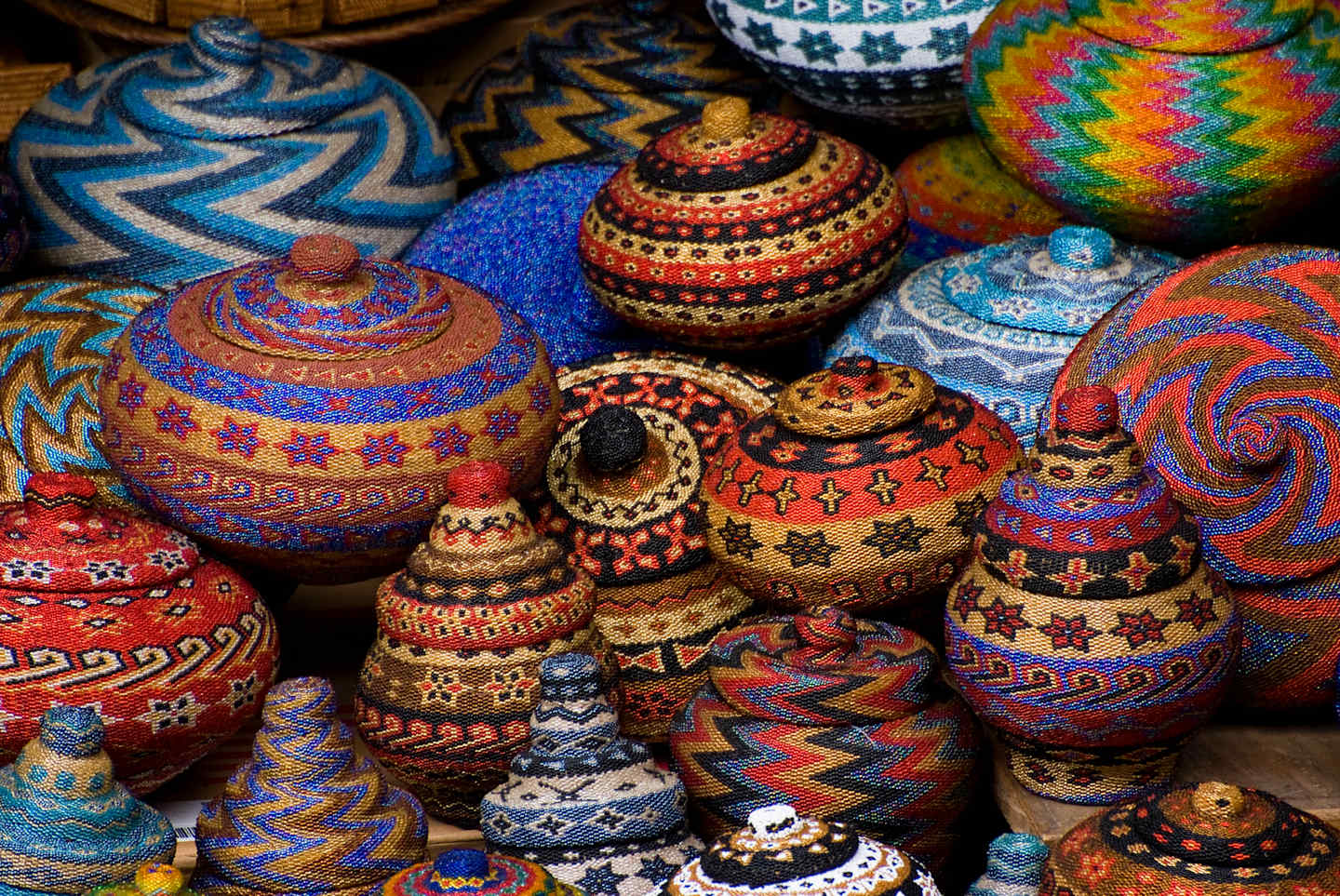 A vibrant collection of intricately decorated ceramic vessels, featuring a variety of patterns, colors, and shapes, creating a visually captivating display.