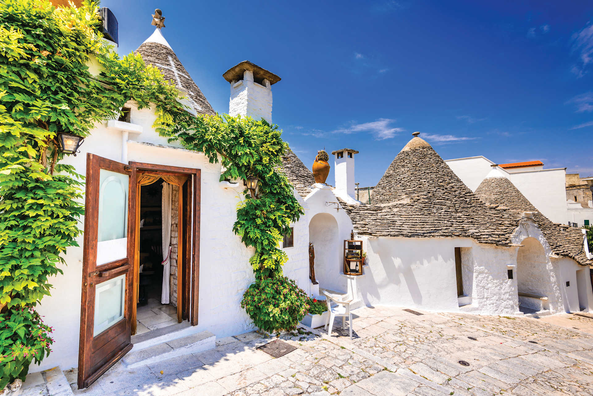 ALBEROBELLO, ITALY - 10 JULY 2015: Alberobello, UNESCO heritage city in Italy, Puglia. Trulli or Trullo houses with conical roofs, traditional Apulian dry stone hut.