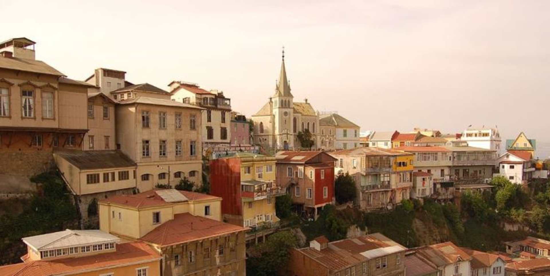 A picturesque European city with a mix of historic buildings, churches, and colorful houses nestled on a hillside, creating a charming and scenic landscape.