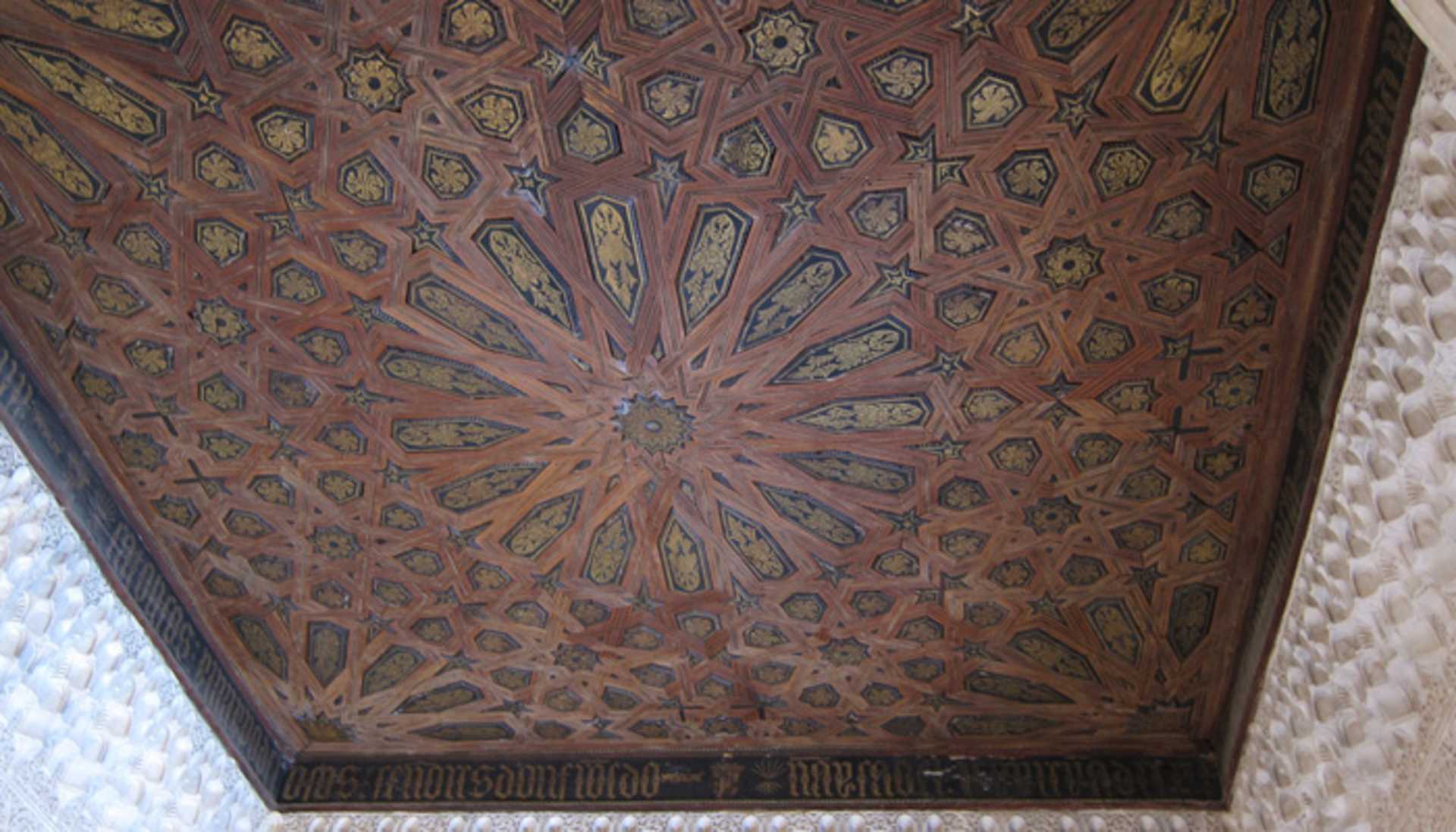 A richly decorated ceiling with intricate geometric patterns and vibrant colors, creating a visually stunning and ornate architectural feature.