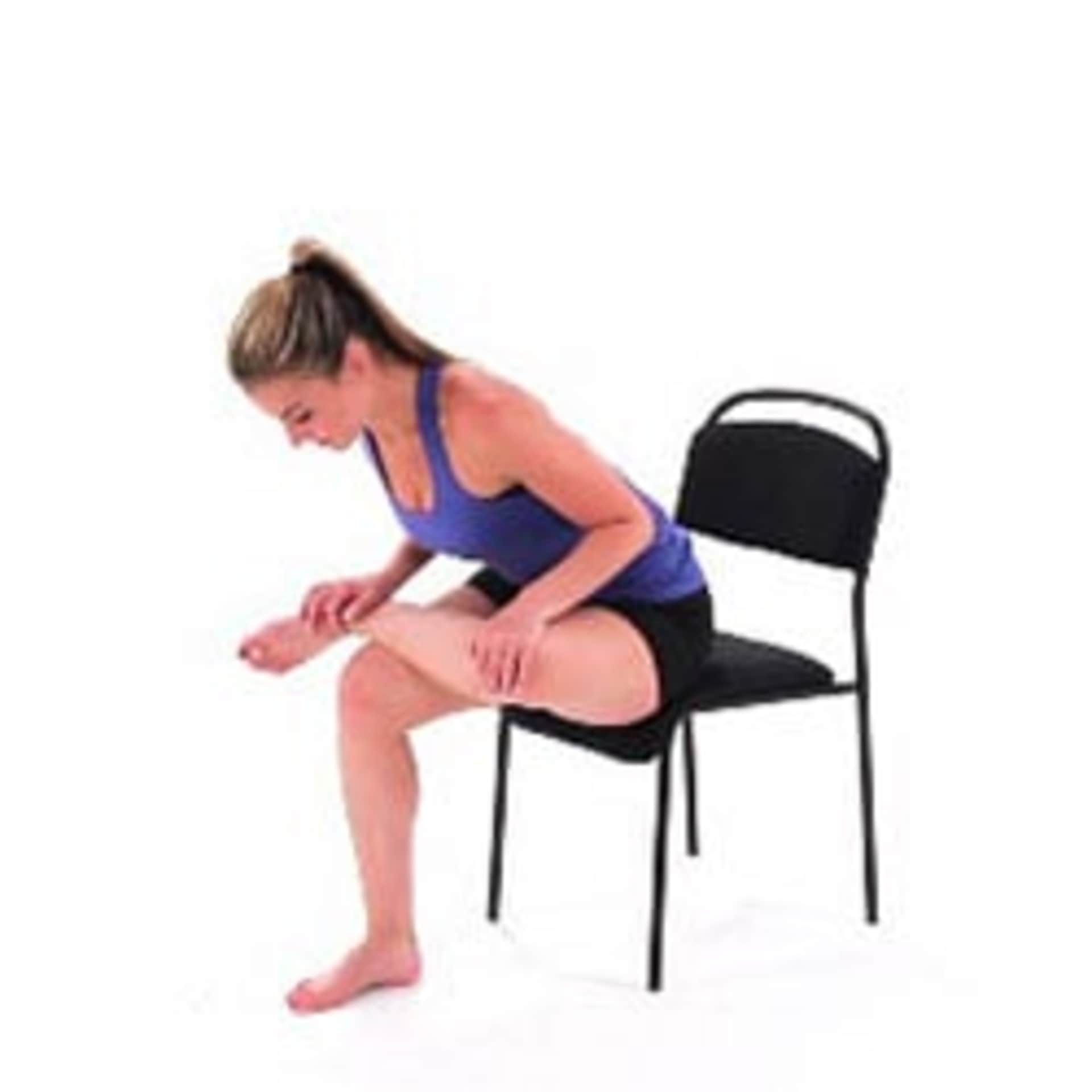 A woman in athletic clothing is sitting on a chair, appearing to be resting or stretching.