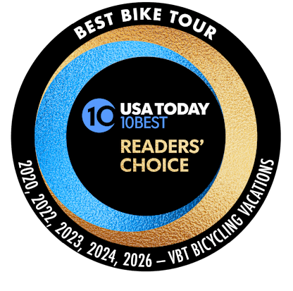 A circular award badge with "BEST BIKE TOUR" at the top, "USA TODAY 10BEST READERS' CHOICE" in the center, and years and "VBT BICYCLING VACATIONS" along the bottom curve.