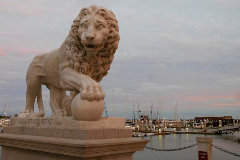Close up of a lion sculpture at the end of the historic Bridge of Lions in Old Town St. Augustine, Florida, USA, at sunset