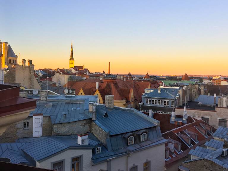 A picturesque cityscape with a mix of historic buildings and modern structures, set against a vibrant sunset sky, creating a captivating and atmospheric scene.