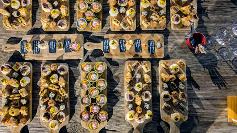 Wooden boards display an assortment of colorful, freshly prepared dishes on a rustic wooden surface.