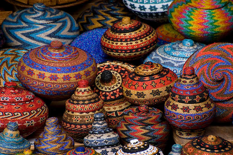 A vibrant collection of intricately decorated ceramic vessels, featuring a variety of patterns, colors, and shapes, creating a visually captivating display.