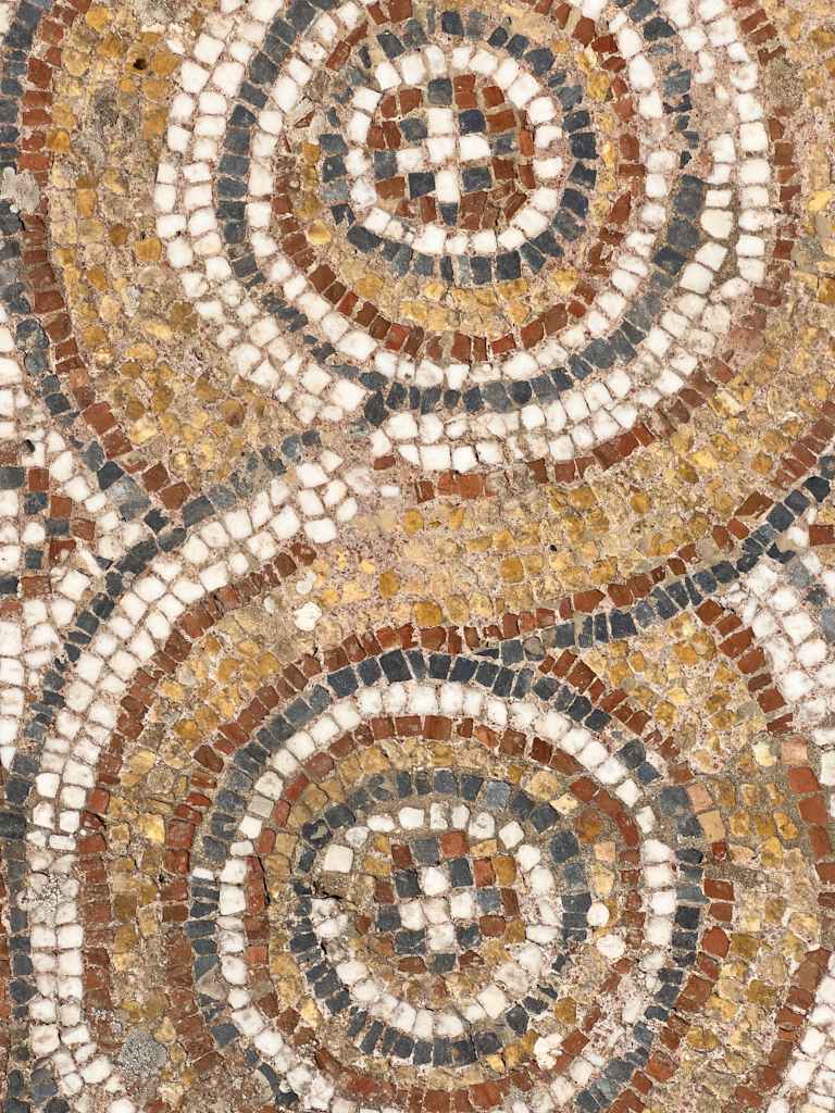 A vibrant mosaic pattern featuring intricate swirling designs in shades of brown, beige, and white, creating a visually captivating and intricate background.