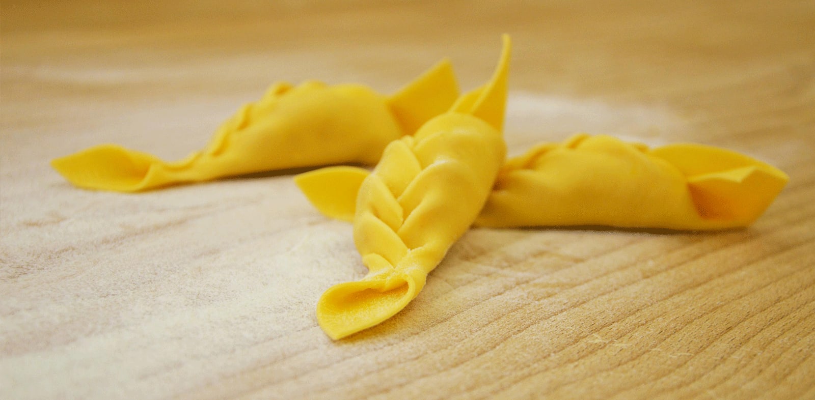 Caramelle di pasta fresca disposte su un piano chiaro