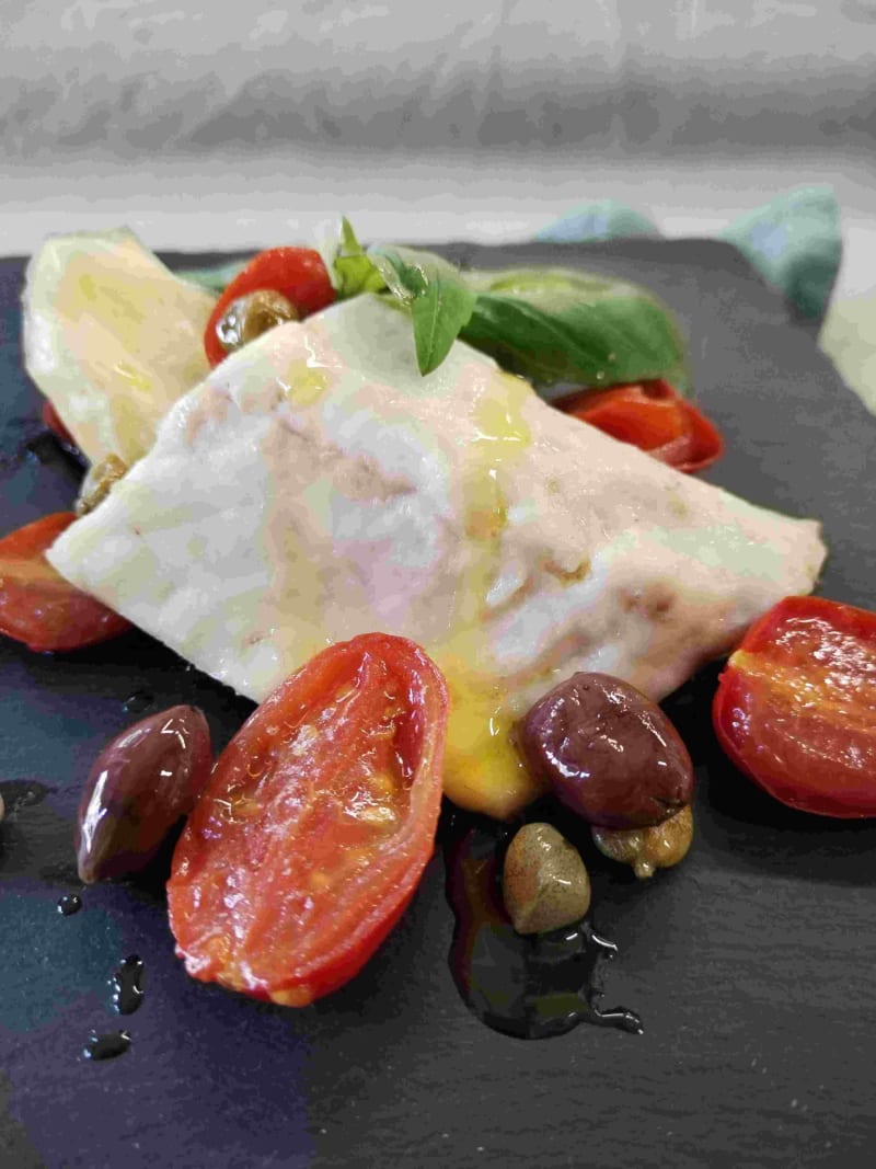 Filetti di branzino con olive taggiasche, capperi e pomodorino fresco.