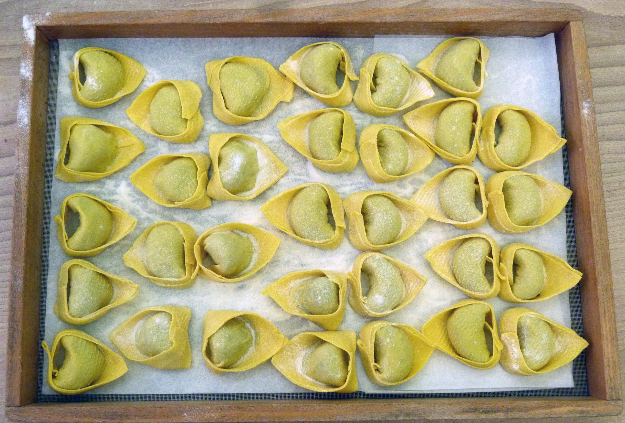 Un vassoio di legno con tortelli di pasta fresca crudi, foto usata per il collaudo