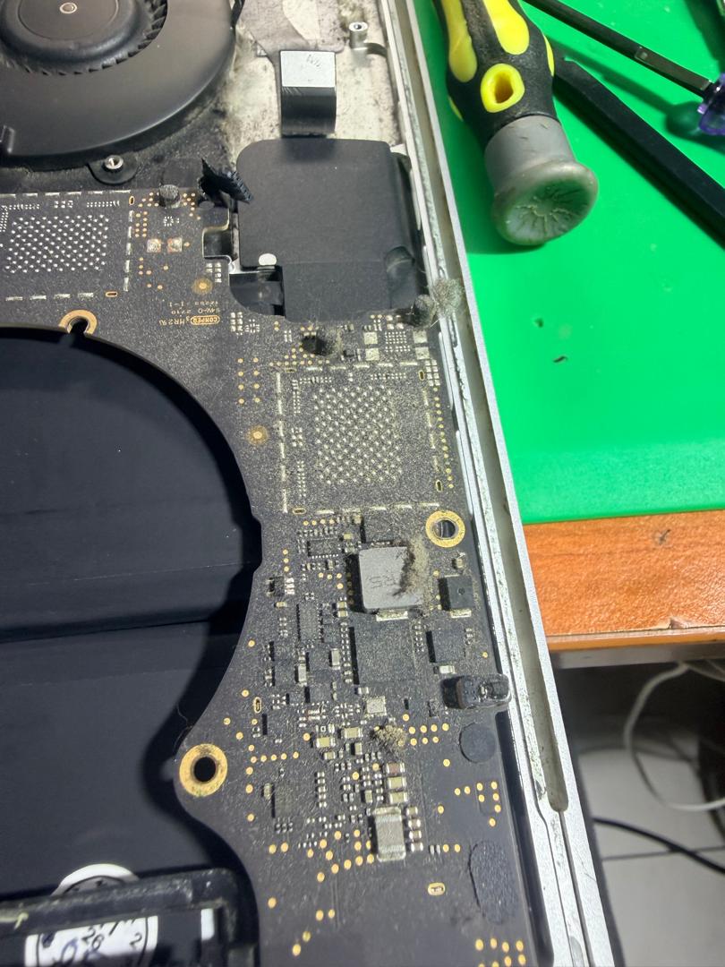 Pandangan dekat bahagian papan logik MacBook Pro A1990 dengan habuk