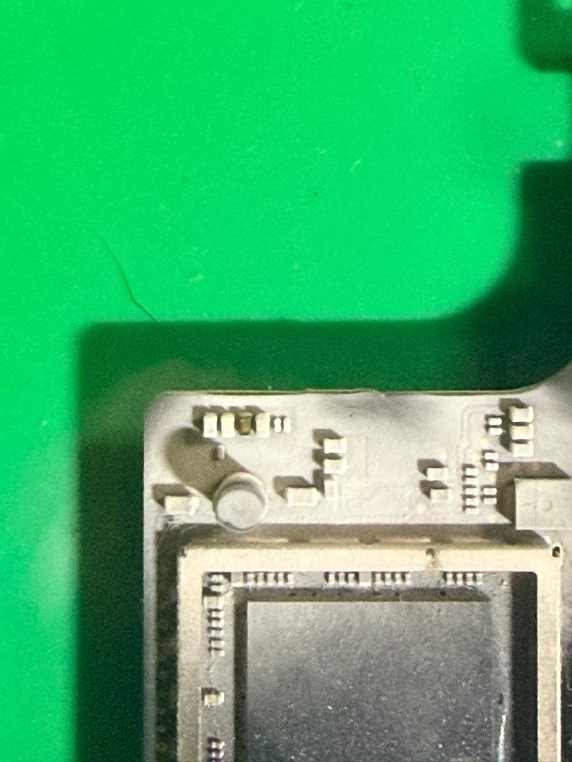Foto makro komponen dalaman MacBook Pro A1990 semasa pemeriksaan