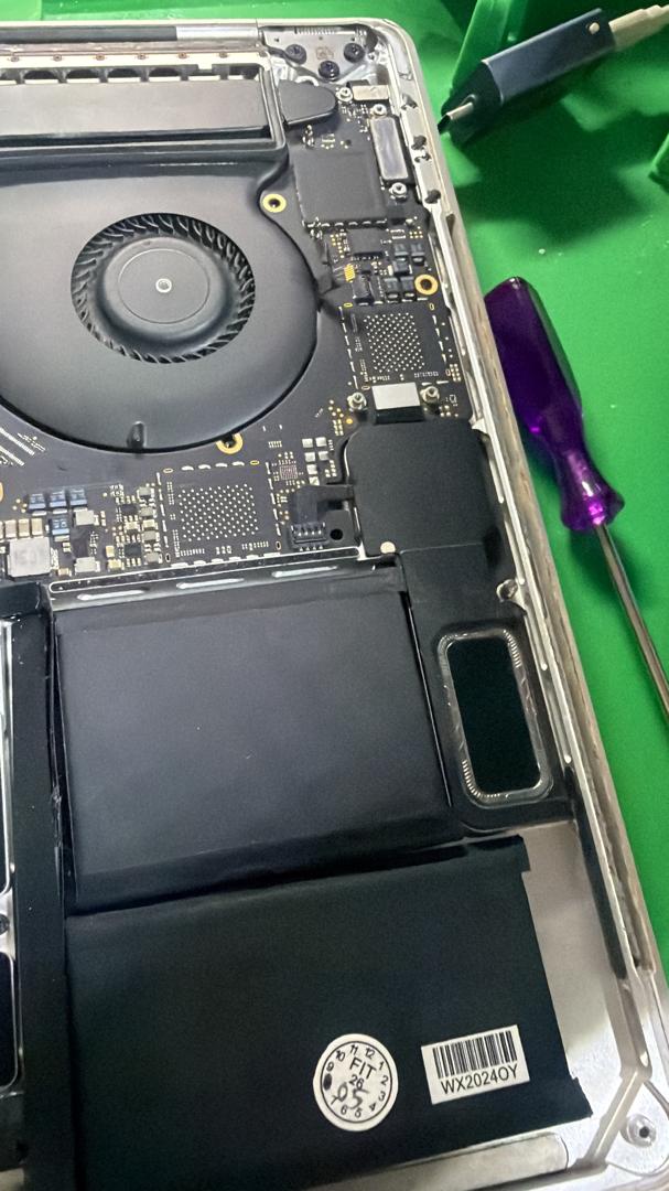 Kipas dan papan logik MacBook Pro A1990 yang dibuka untuk pemeriksaan