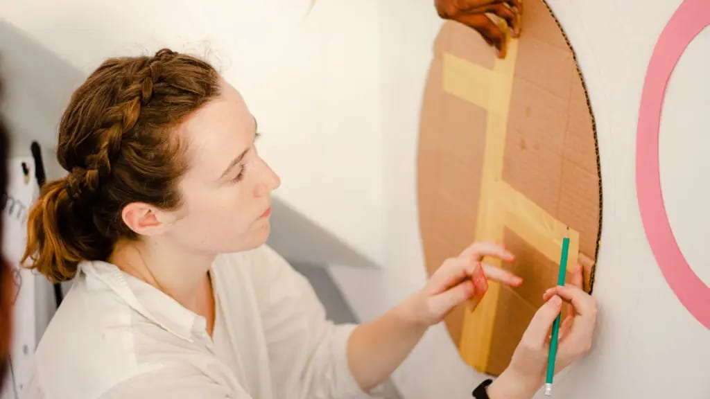 Tracing a cardboard template onto the wall. Photo: DreamSpace Story Lab.