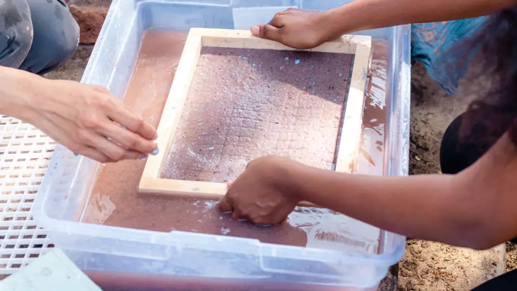 Dipping a mould and deckle into the pulp, July 2022. Photo: Dinacon 2022.