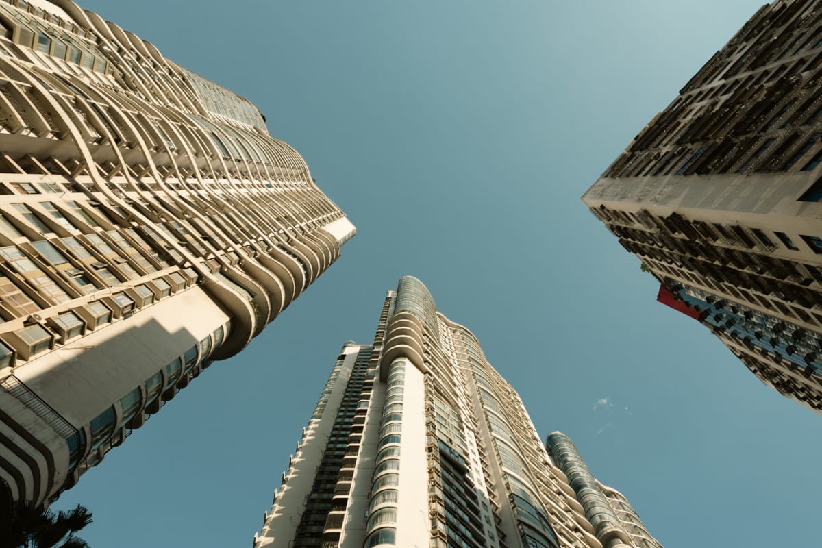 High-rise buildings curving inward around a clear blue sky