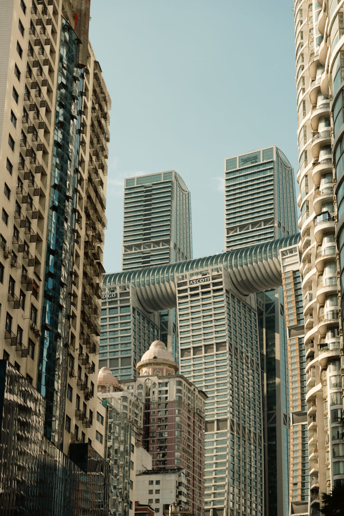 Layered towers and residential buildings rising above a Chongqing street