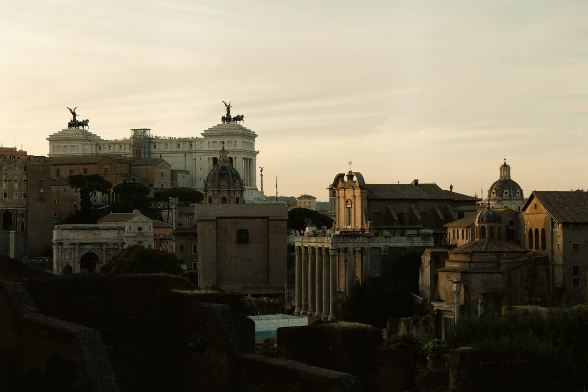 Ancient Roman ruins and domes glowing in late afternoon light