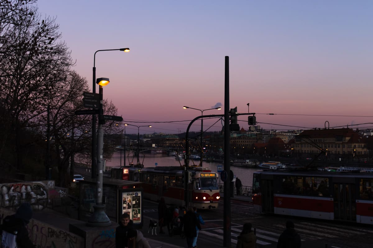 Red trams gathering beside the river at dusk