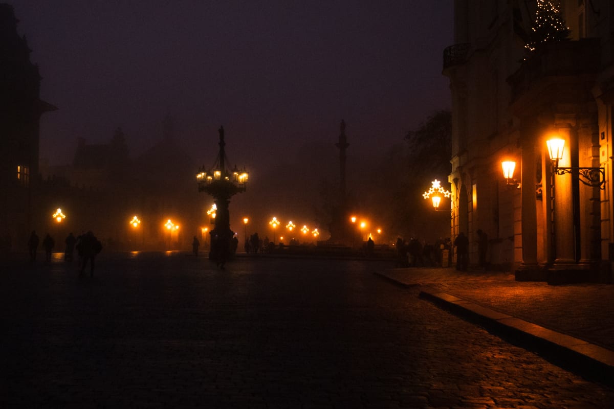 Rows of amber street lamps fading into a misty square