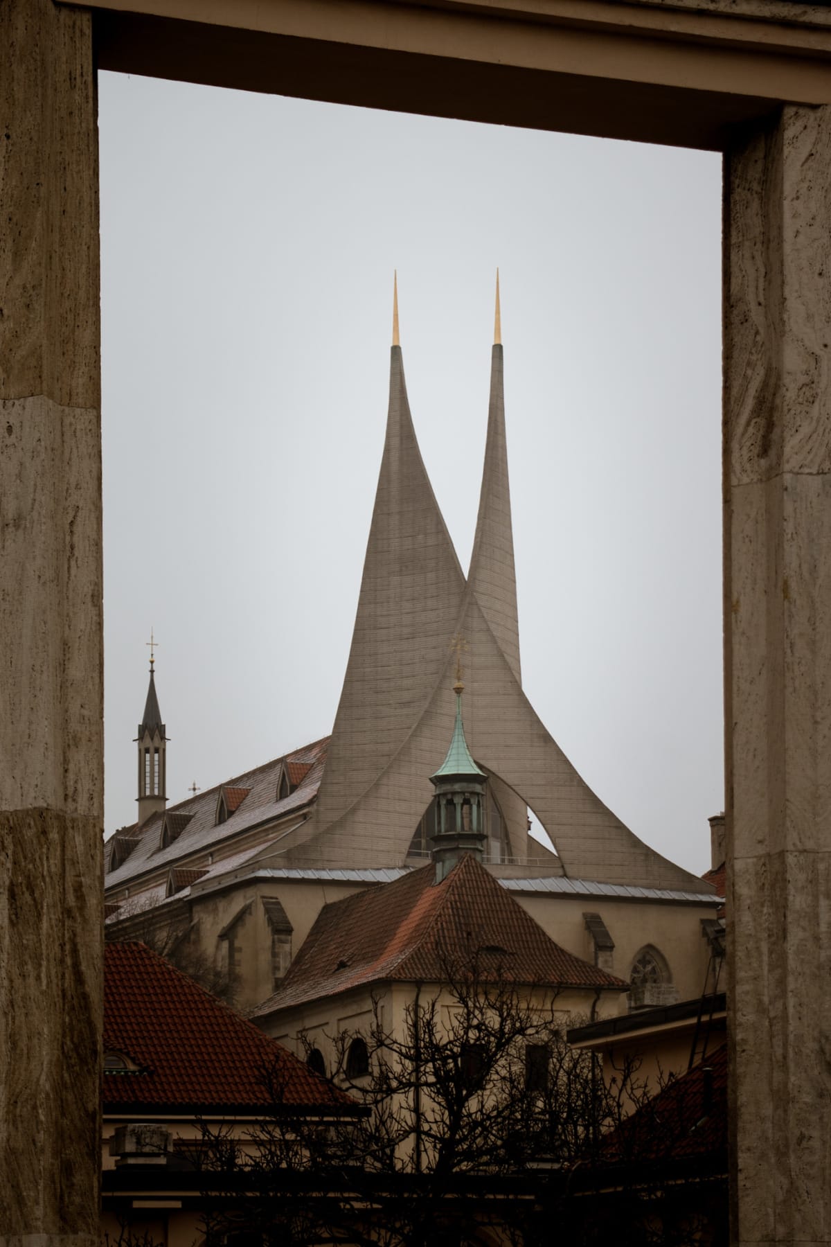 Twin modern church spires framed by a stone opening