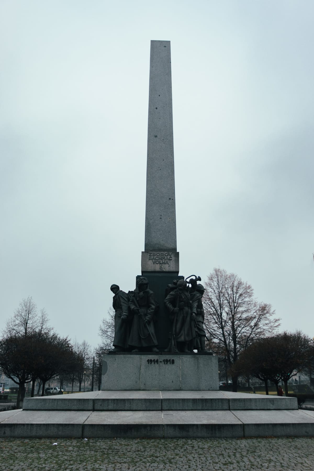 A tall stone obelisk above a group of memorial figures