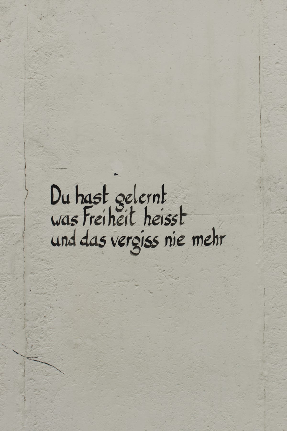 A handwritten German message about freedom on a pale wall