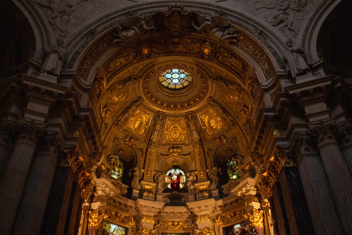 A richly gilded church interior beneath a circular skylight