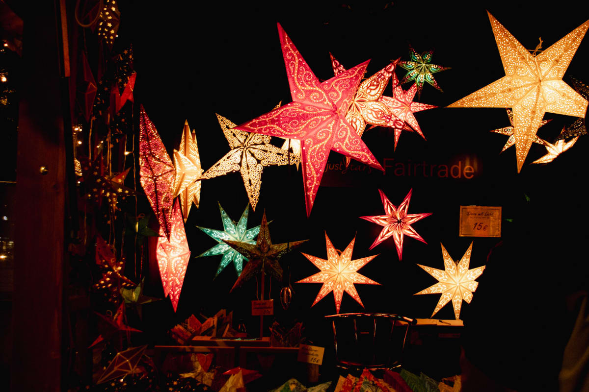 Colourful illuminated stars hanging in a night market