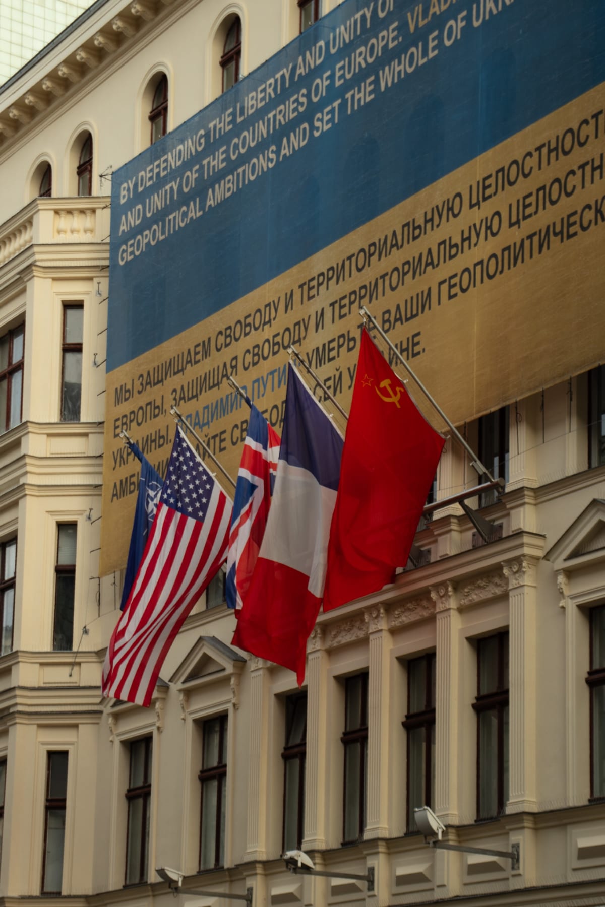 Allied and Soviet flags displayed on a historic Berlin façade
