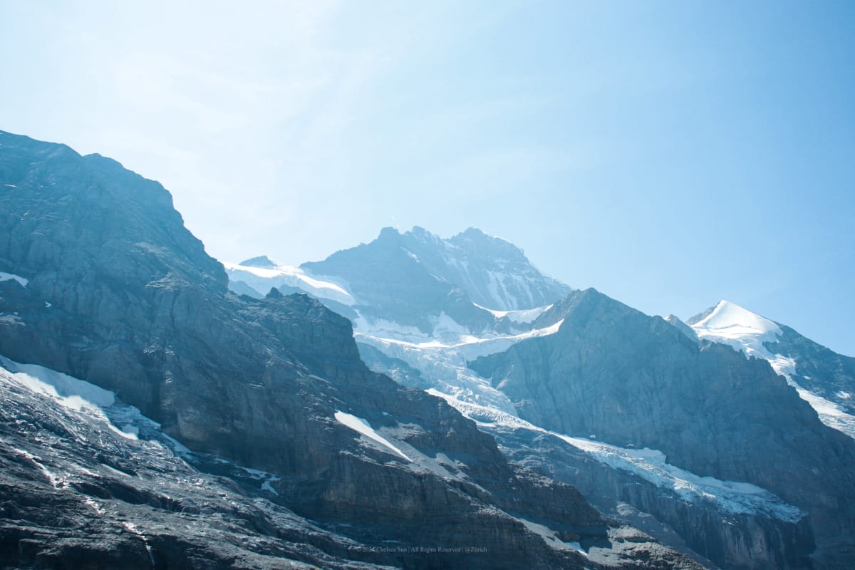 Rocky alpine peaks and glaciers beneath a clear blue sky