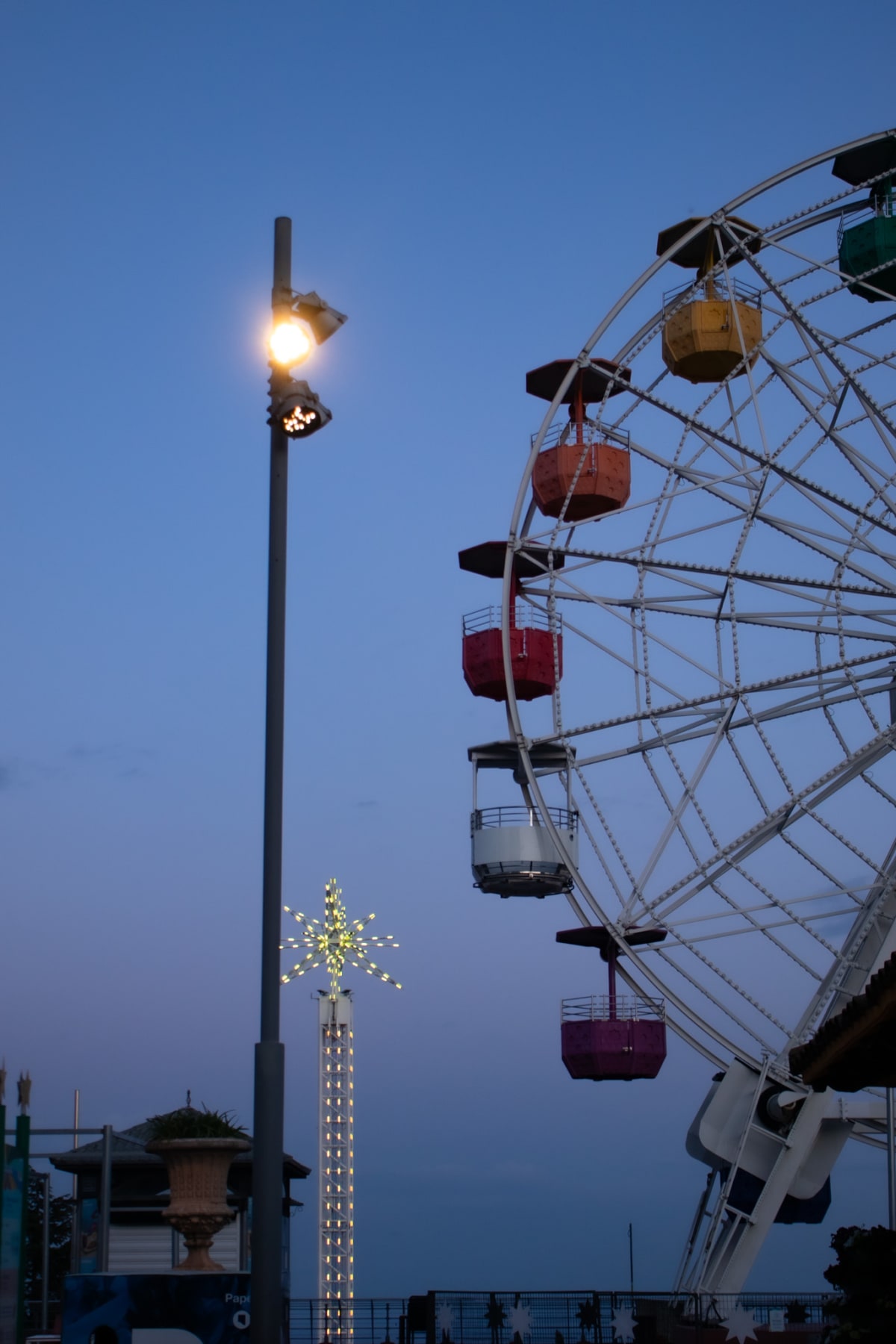 A colourful Ferris wheel illuminated against the evening sky