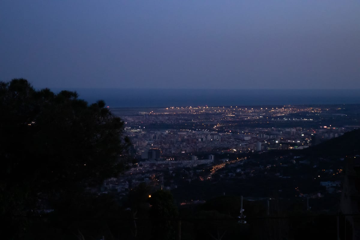 Barcelona city lights stretching toward the sea at dusk
