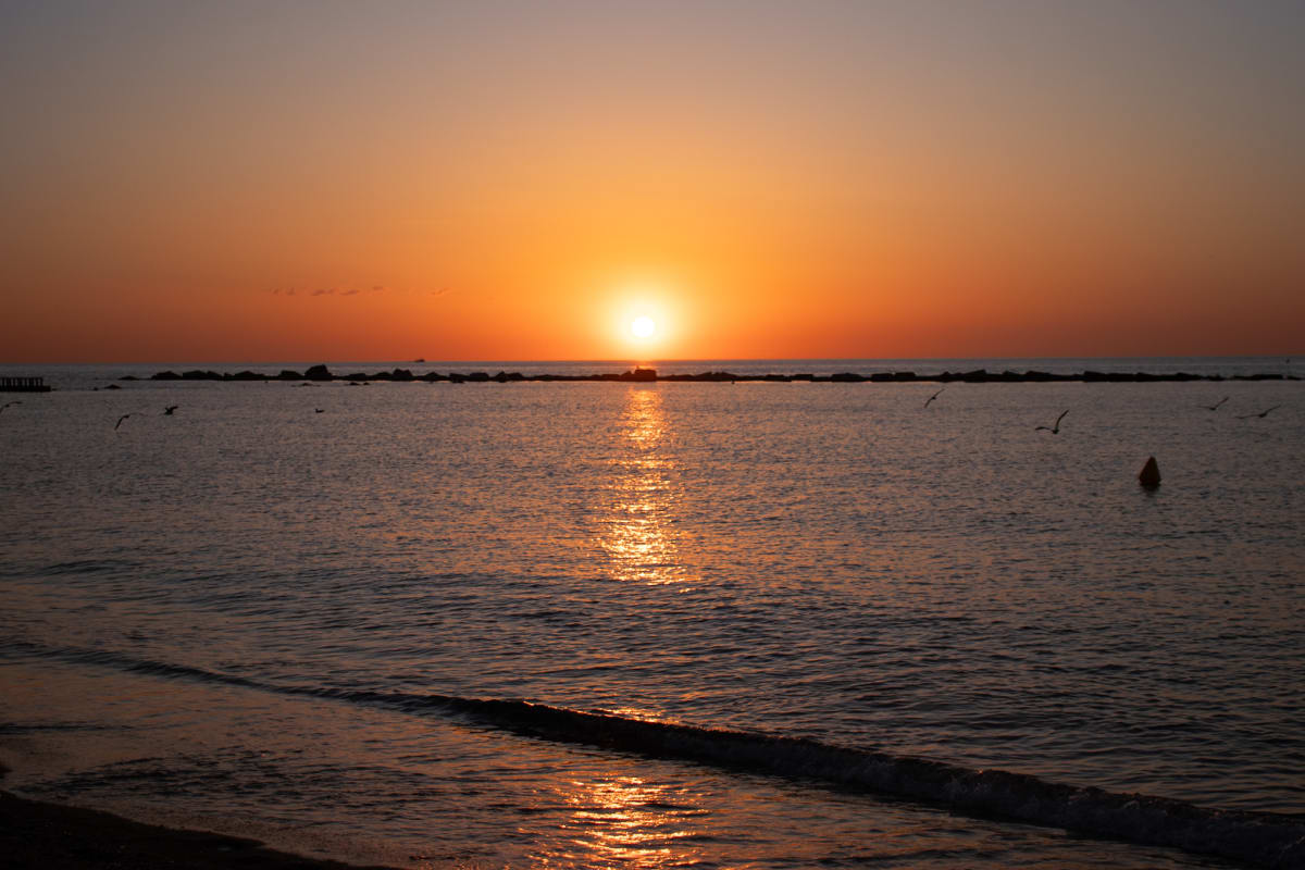 The setting sun reflected across calm Mediterranean waves