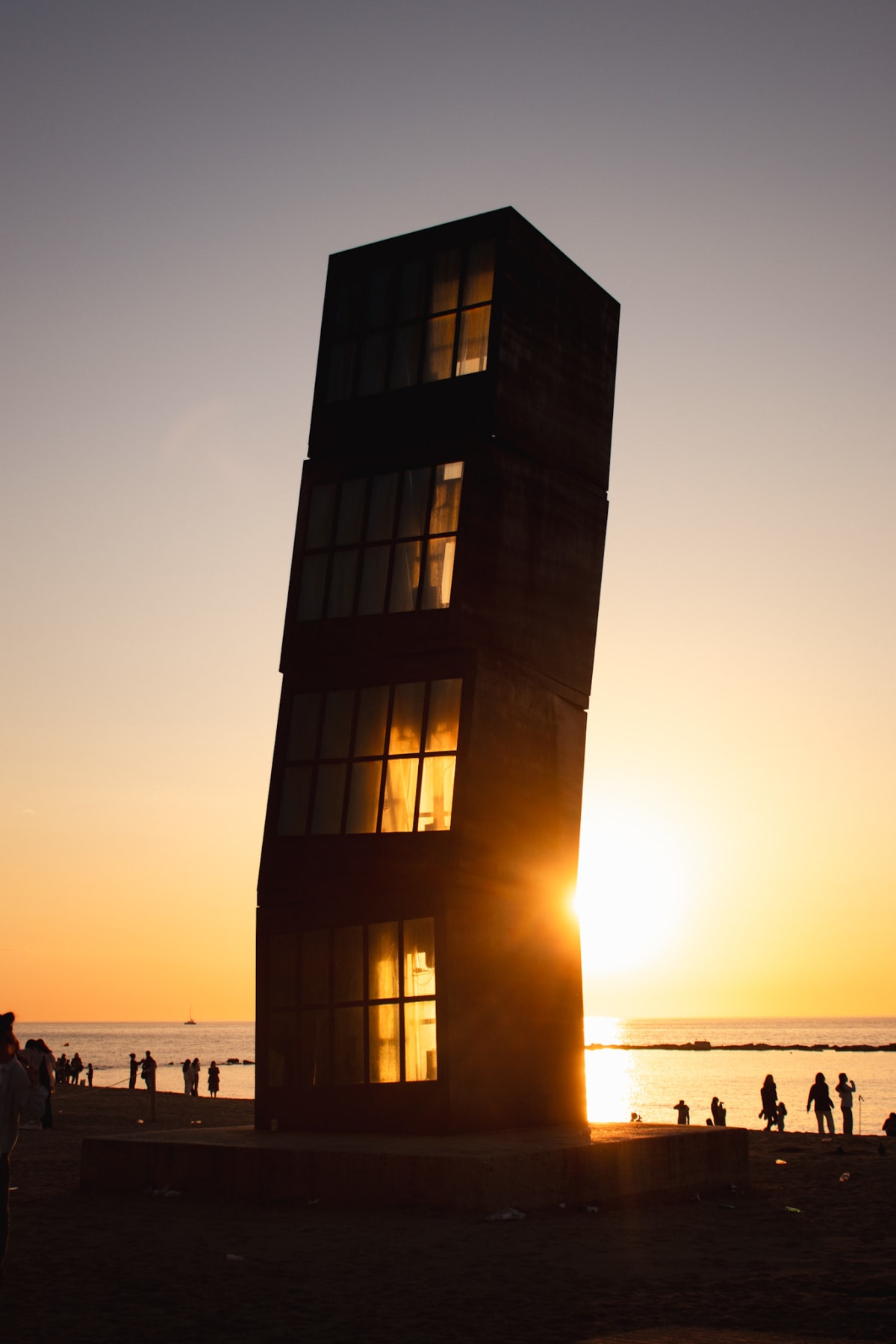 A dark beachside tower silhouetted against a golden sunset