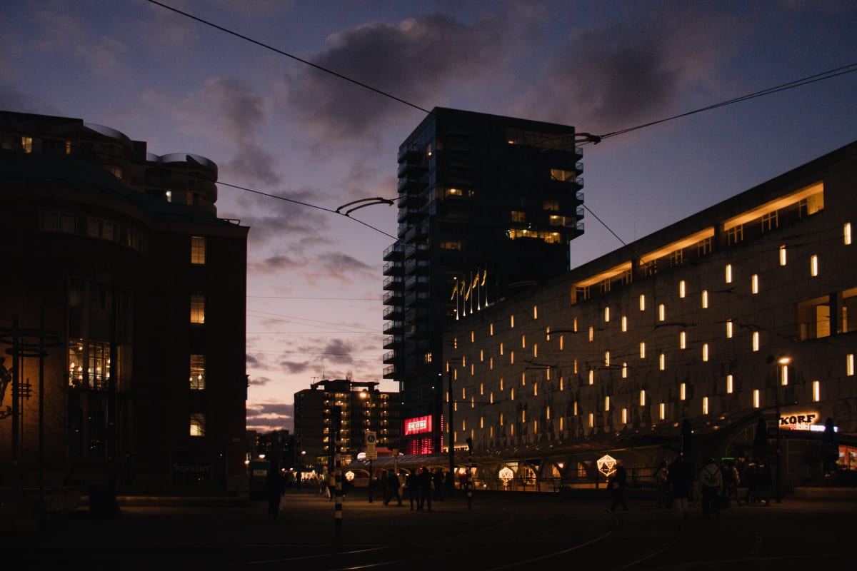 Modern buildings and street lights glowing beneath a purple evening sky