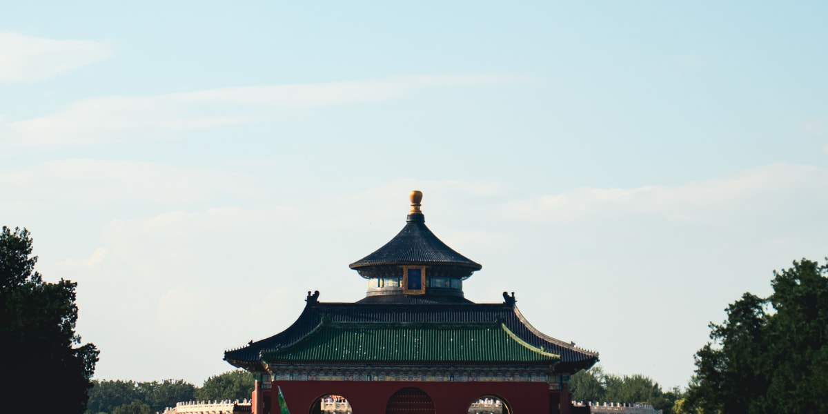 A traditional temple rising above dark green trees