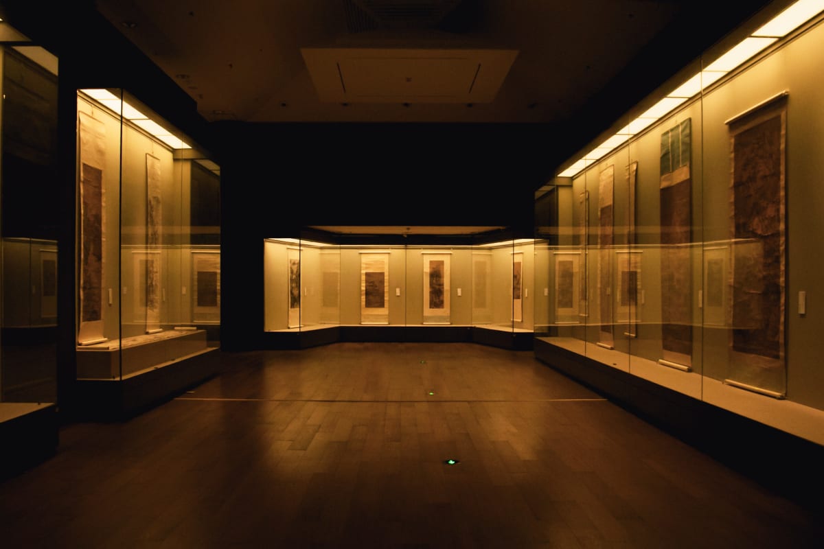 Illuminated scroll paintings displayed in a quiet museum gallery