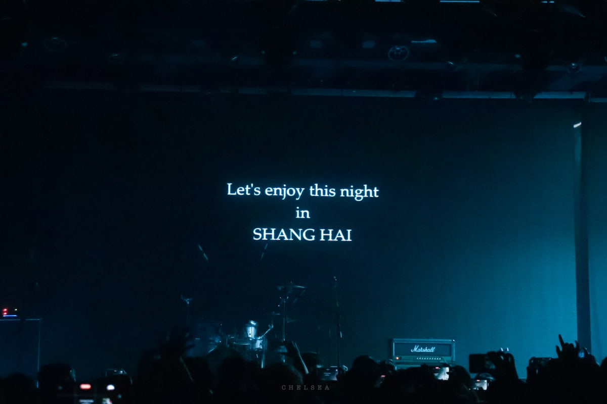 A dim stage screen welcoming the audience to a night in Shanghai