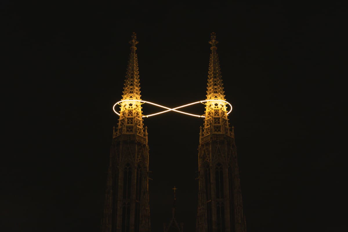 Twin Gothic spires connected by looping white lights at night