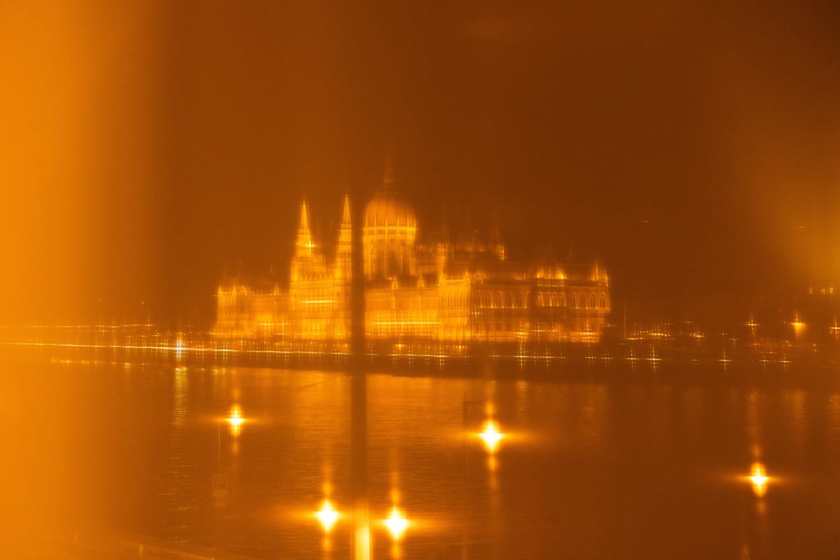 The Hungarian Parliament rendered as soft golden reflections at night