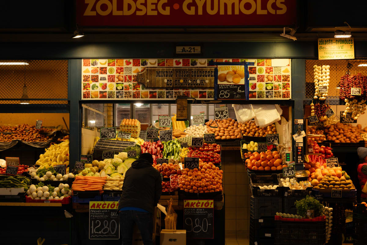 A colourful fruit and vegetable stall inside a market hall