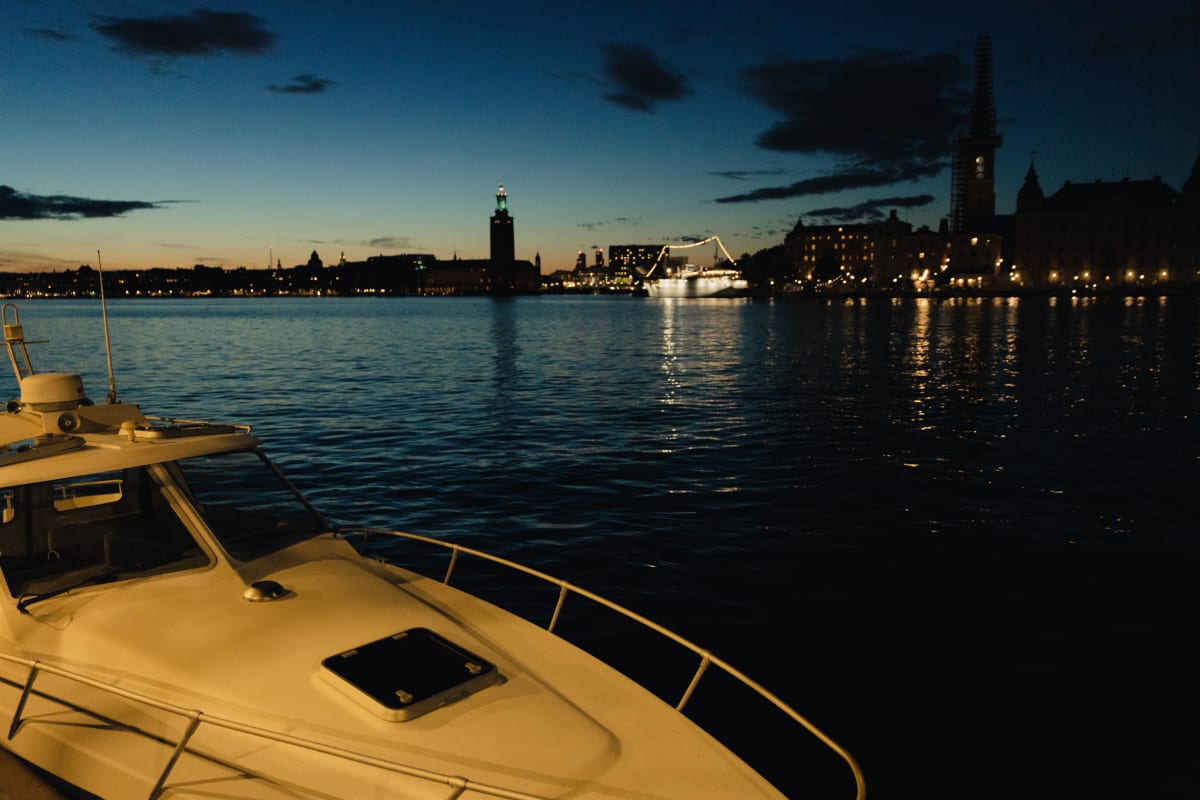 A boat in the foreground of Stockholm’s waterfront at twilight
