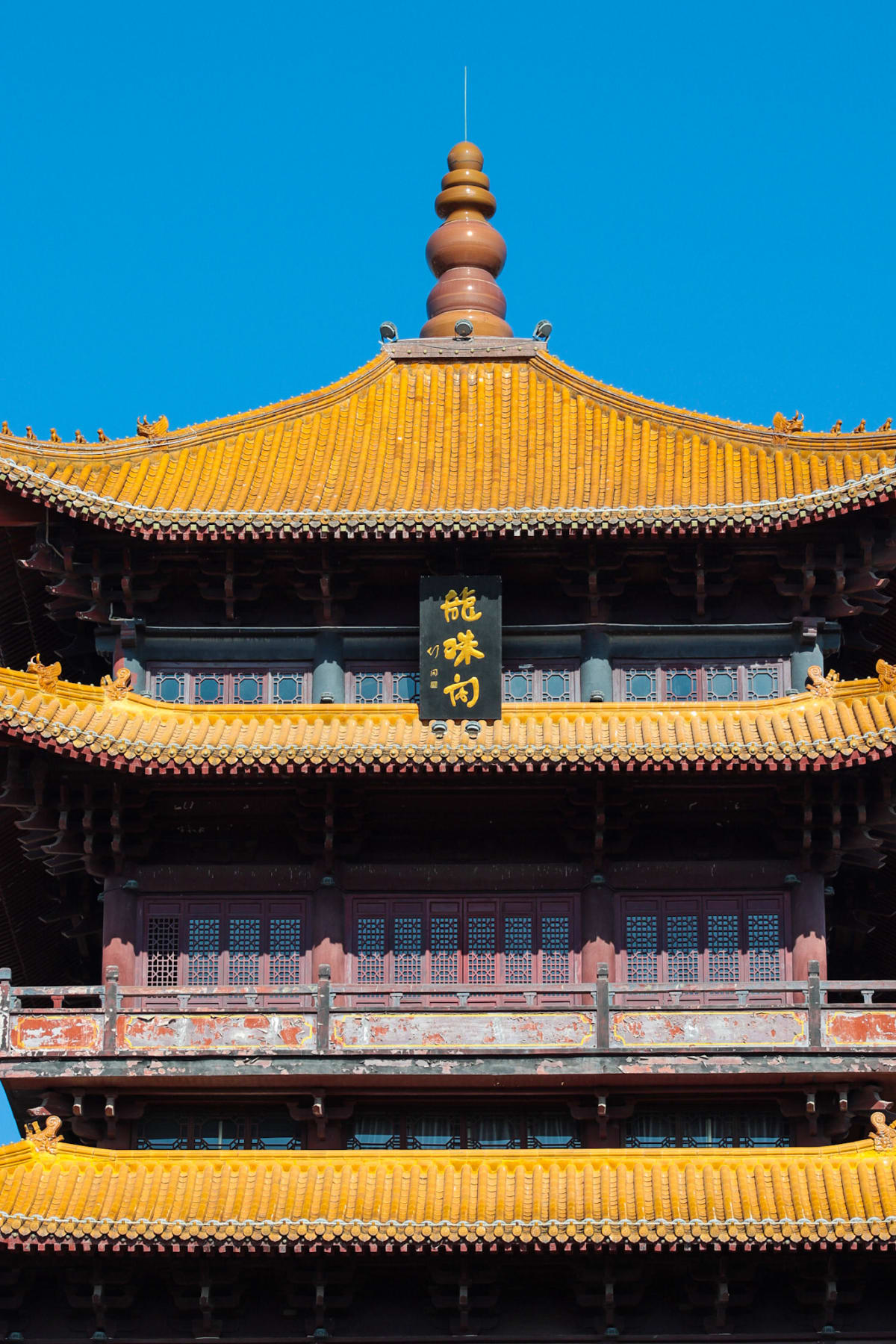A golden-roofed pagoda glowing beneath a vivid blue sky