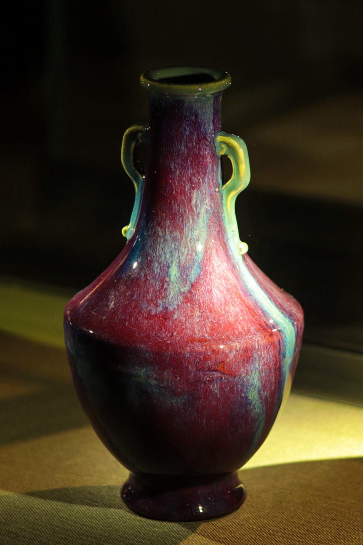 A richly glazed purple and turquoise ceramic vase