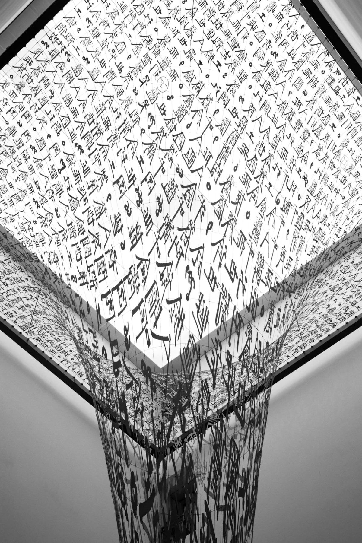 A black-and-white installation covered in layered handwritten characters