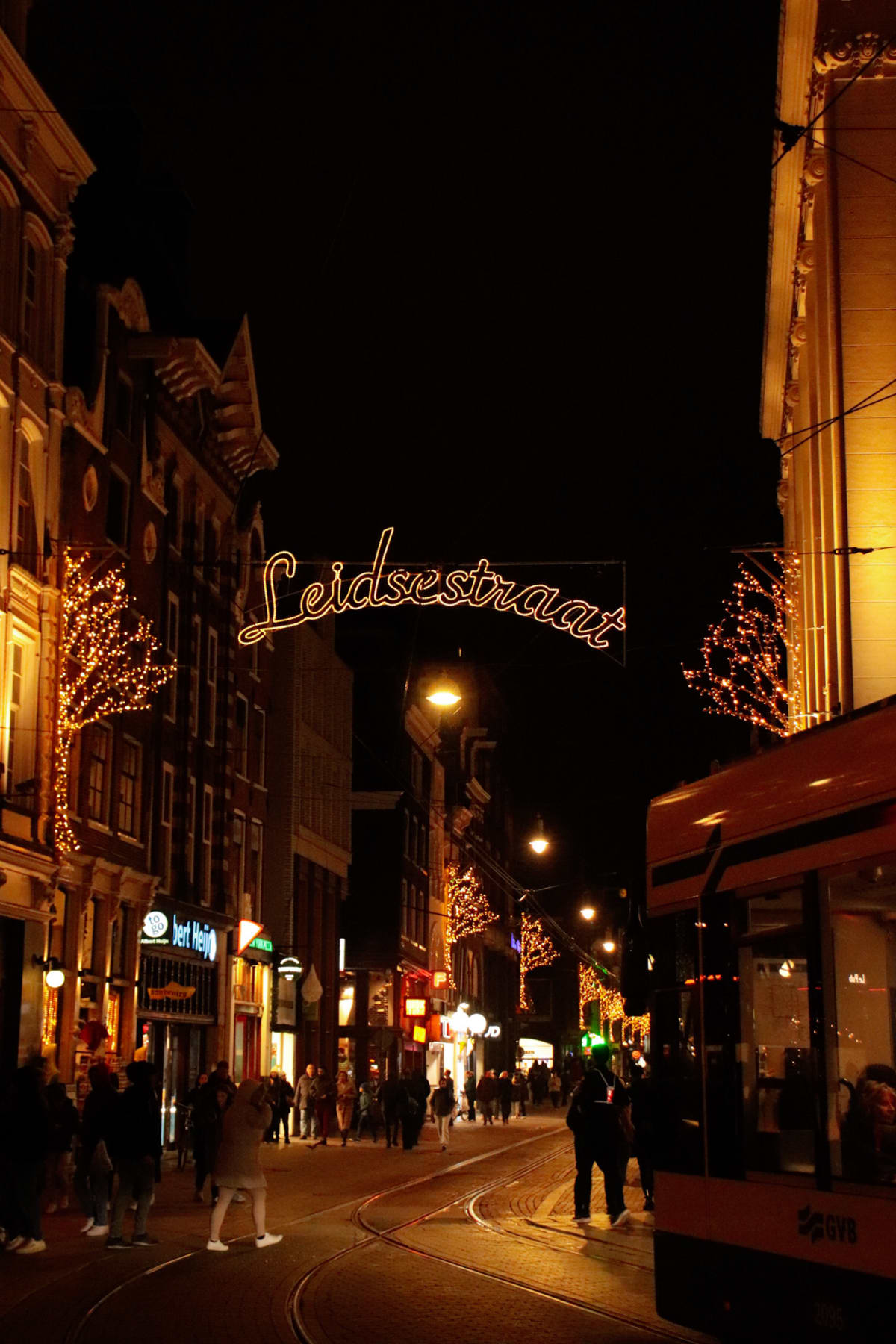 Christmas lights and a tram illuminating Leidsestraat at night