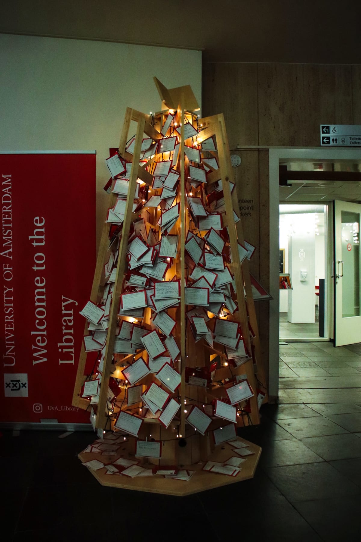 A Christmas tree made from handwritten cards inside a university library
