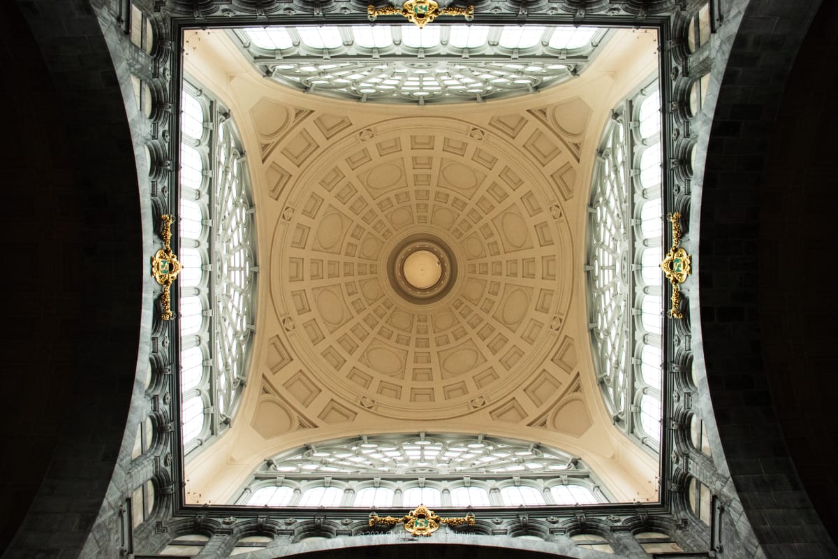 An ornate geometric station ceiling framed by dark stone arches